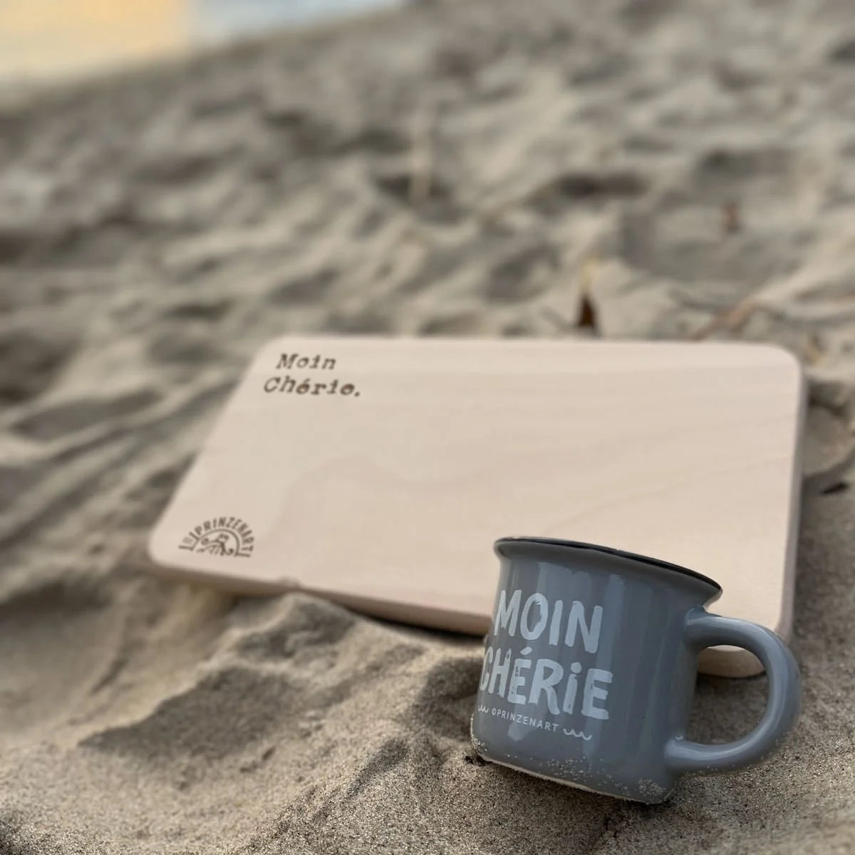 Frühstücksbrettchen Moin Chérie mit blauer Tasse am Strand im Sand | Prinzenart