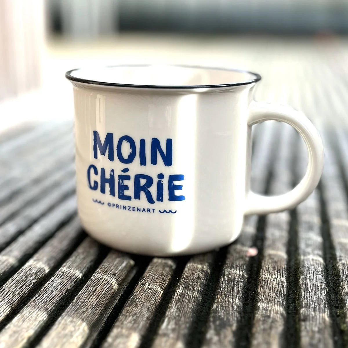 Weiße Vintage-Kaffeetasse Moin Chérie mit blauer Schrift auf Holztisch | Prinzenart
